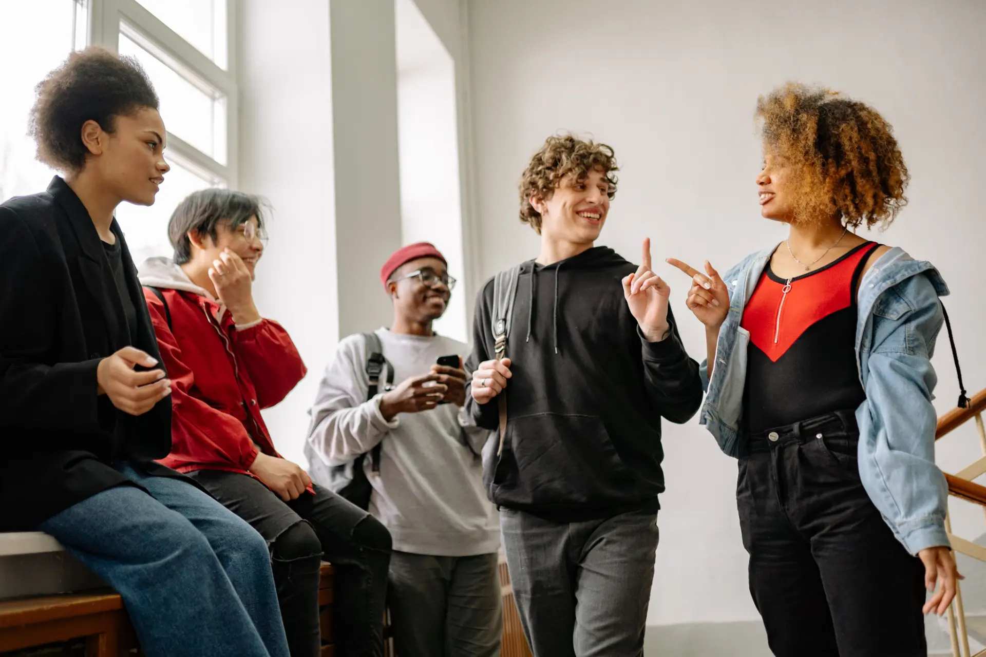 Students talking together in a bright hallway