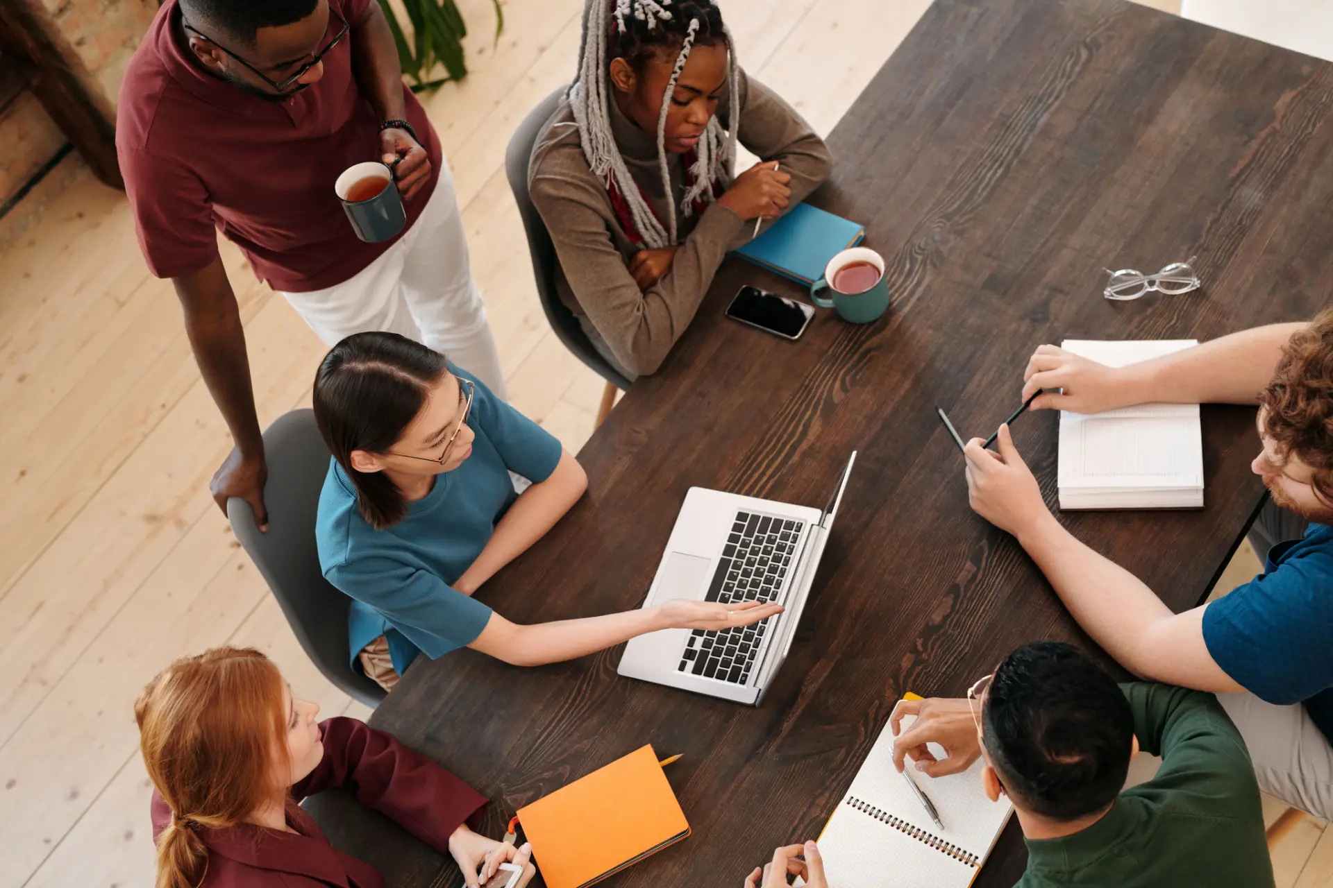 A group reviewing research notes and a laptop around a table