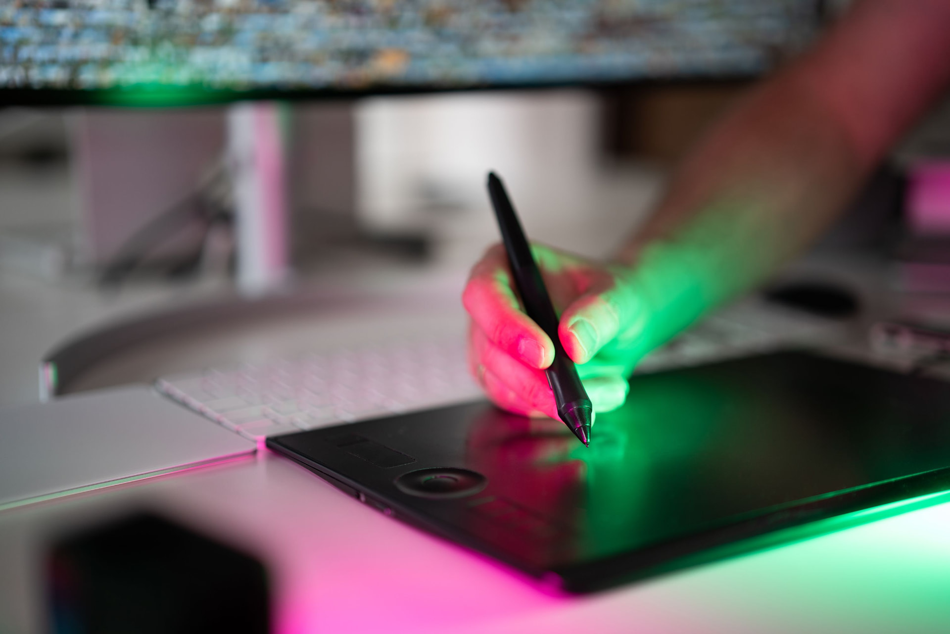 Hand drawing on a graphics tablet under coloured light