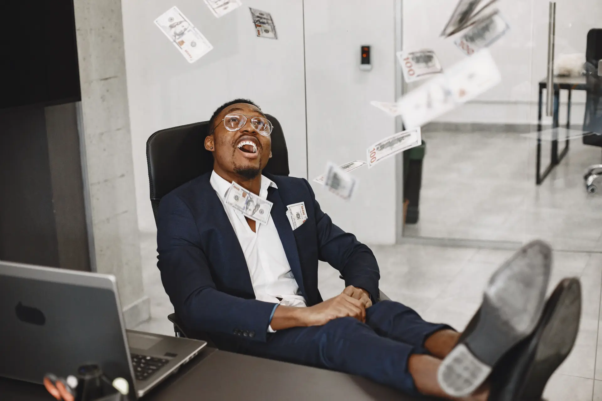 A worker leaning back at a desk in an office late in the day